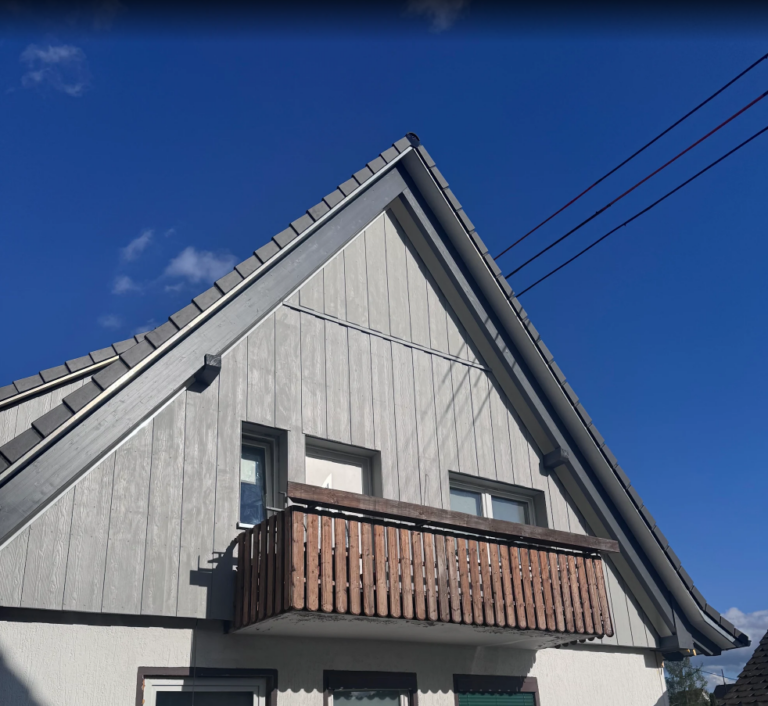 Metallfassade bei Oliver K.: Ansicht der Giebelseite mit Balkon.